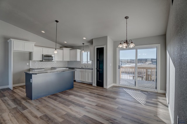 kitchen with hanging light fixtures, light hardwood / wood-style flooring, a center island, and white cabinetry