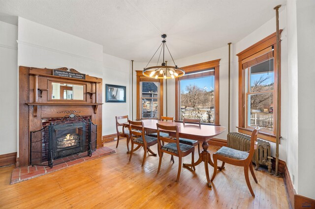 735 8th, Spearfish, SD 57783 - dining area featuring light wood-type flooring, a chandelier, and a brick fireplace