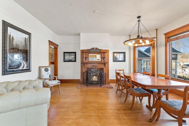 735 8th, Spearfish, SD 57783 - dining area featuring light hardwood / wood-style floors, a notable chandelier, and a fireplace