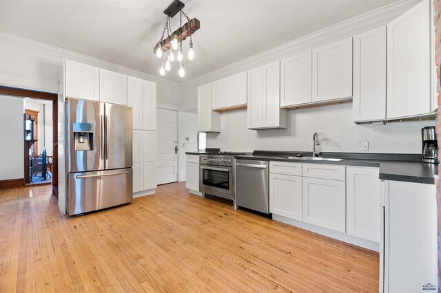 735 8th, Spearfish, SD 57783 - kitchen featuring decorative light fixtures, light hardwood / wood-style flooring, white cabinetry, appliances with stainless steel finishes, and sink