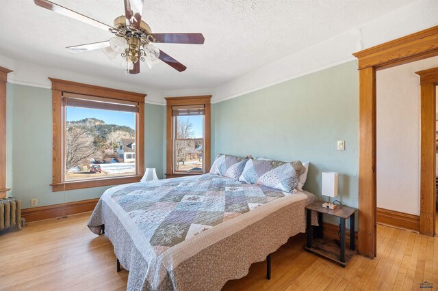 735 8th, Spearfish, SD 57783 - bedroom featuring light hardwood / wood-style floors, ceiling fan, and a textured ceiling