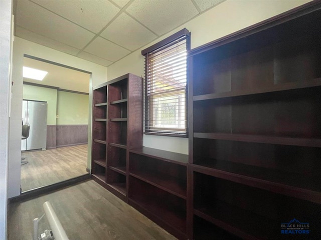 interior space featuring a drop ceiling and hardwood / wood-style flooring