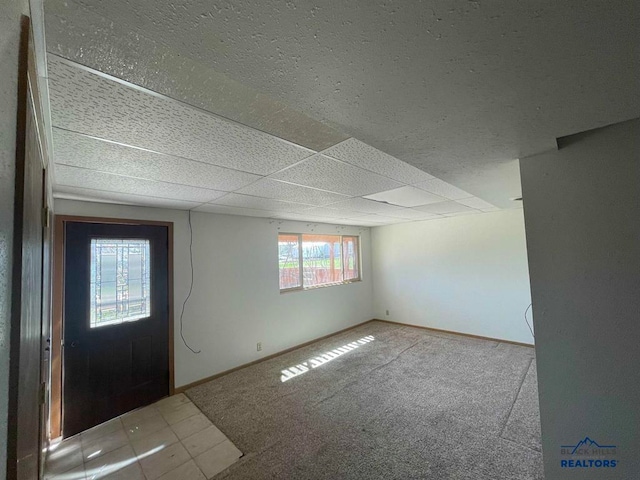 entryway featuring a paneled ceiling and carpet