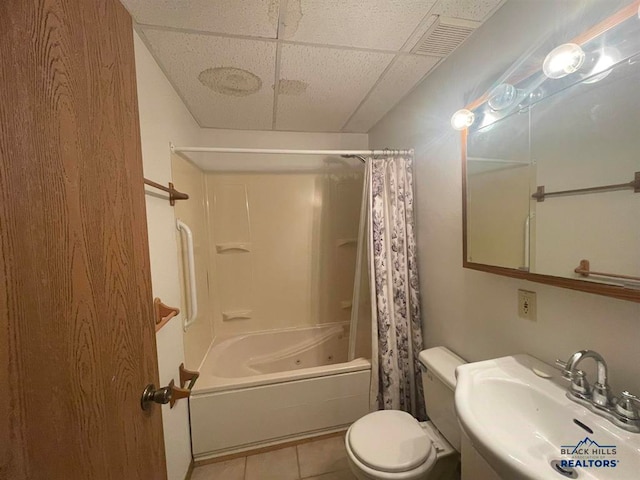 full bathroom with shower / tub combo, a drop ceiling, tile flooring, sink, and toilet