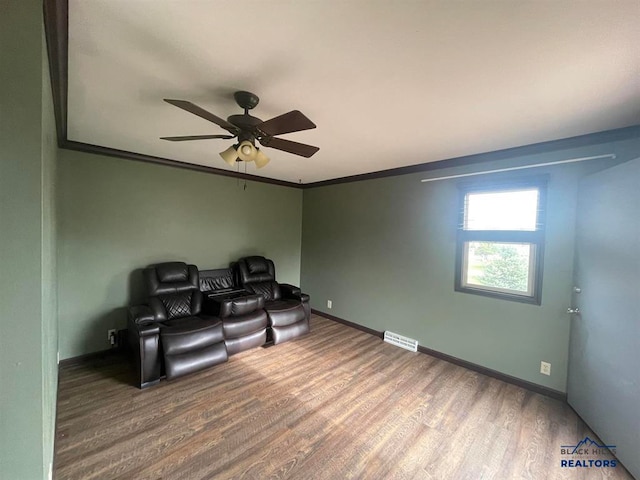 sitting room with wood-type flooring, ceiling fan, and crown molding