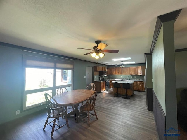 dining space with a healthy amount of sunlight, dark hardwood / wood-style flooring, and ceiling fan