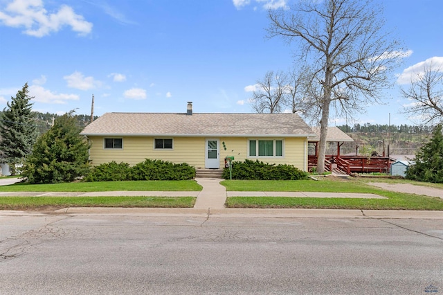 ranch-style home featuring a deck and a front lawn