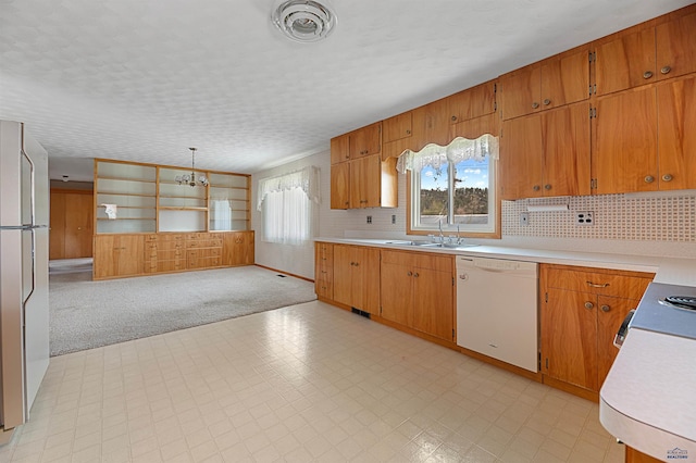 kitchen with hanging light fixtures, white appliances, backsplash, light tile floors, and sink