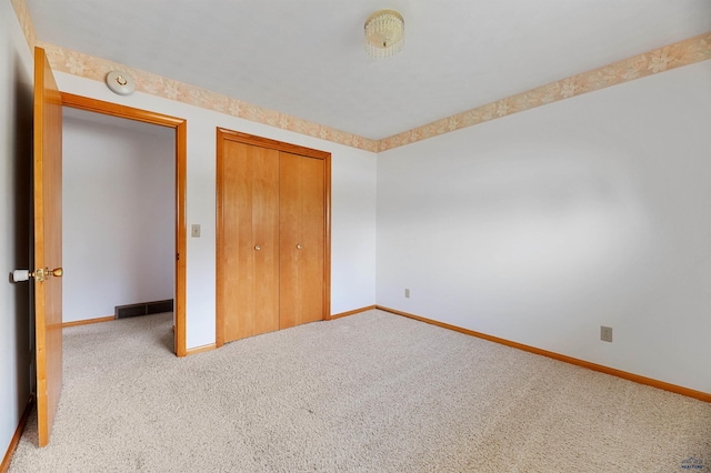 unfurnished bedroom featuring carpet flooring and a closet