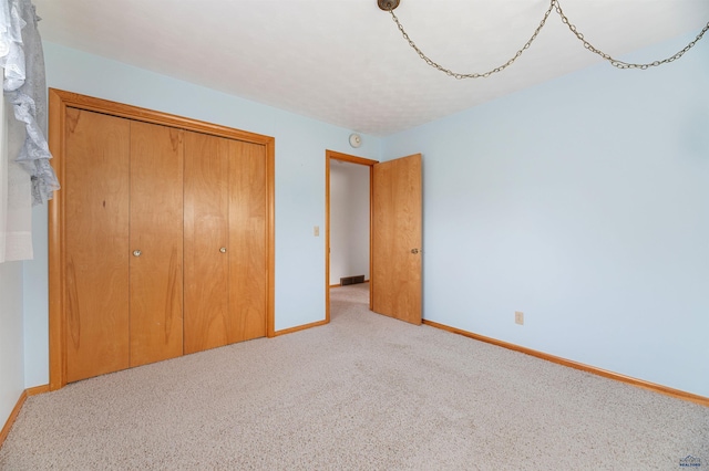 unfurnished bedroom with a closet and carpet flooring