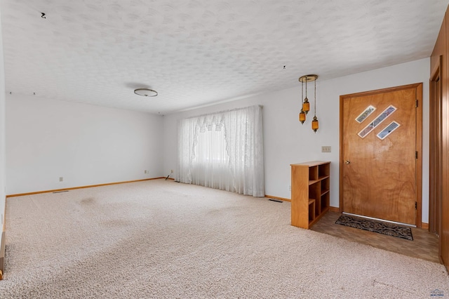 carpeted entryway with a textured ceiling