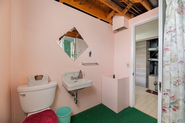 bathroom featuring toilet, tile flooring, and sink