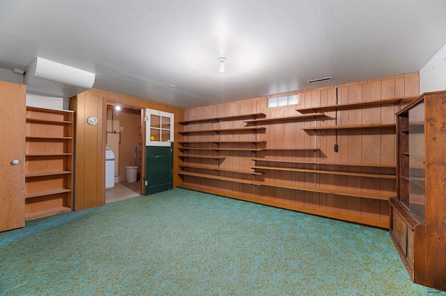 interior space with wooden walls, carpet floors, and washer / dryer