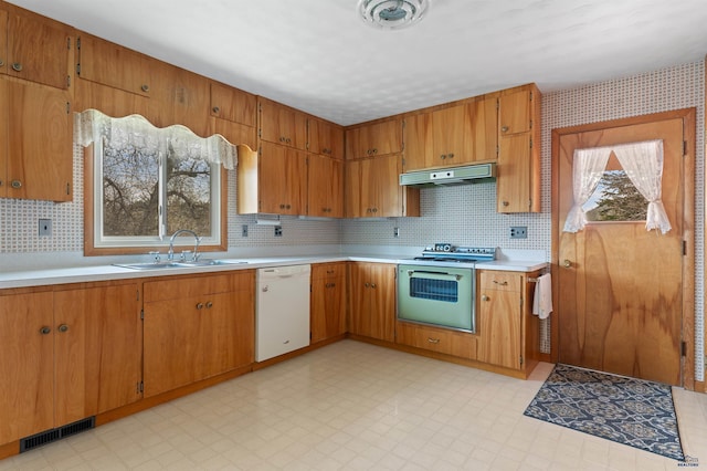 kitchen with sink, dishwasher, light tile floors, and range