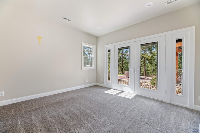 carpeted empty room featuring french doors