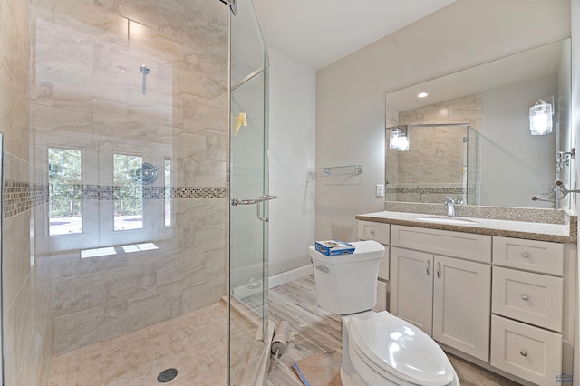 bathroom with a shower with shower door, wood-type flooring, toilet, and large vanity