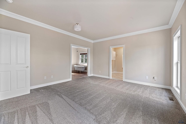 unfurnished bedroom featuring a walk in closet, ornamental molding, and dark colored carpet