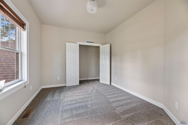 unfurnished bedroom with carpet floors and multiple windows