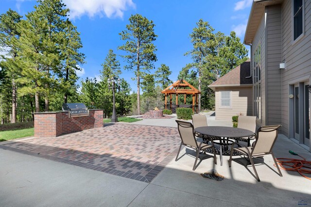 view of patio featuring exterior kitchen, a grill, and a gazebo