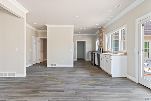 kitchen with stove, white cabinetry, ornamental molding, stainless steel dishwasher, and light wood-type flooring