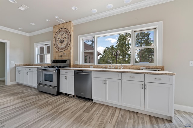 kitchen with light hardwood / wood-style floors, stainless steel appliances, light stone countertops, white cabinets, and sink