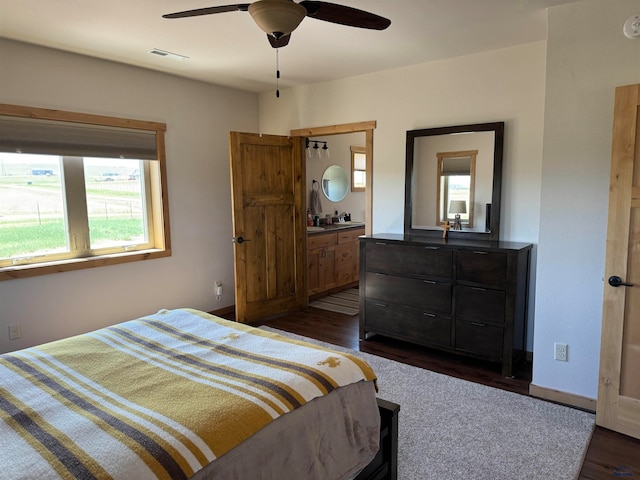 bedroom featuring ceiling fan, dark hardwood / wood-style flooring, and ensuite bath