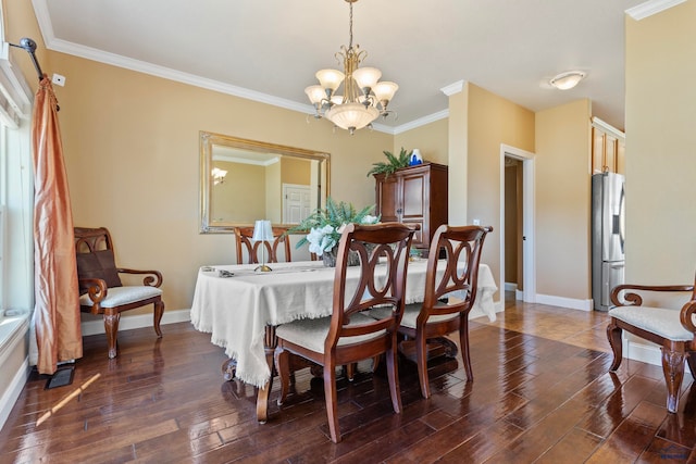 dining space featuring dark hardwood / wood-style floors, a notable chandelier, and ornamental molding