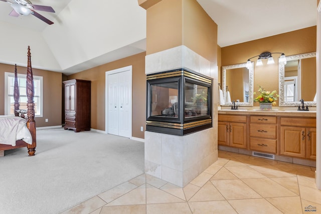 bathroom with tile flooring, large vanity, ceiling fan, and vaulted ceiling