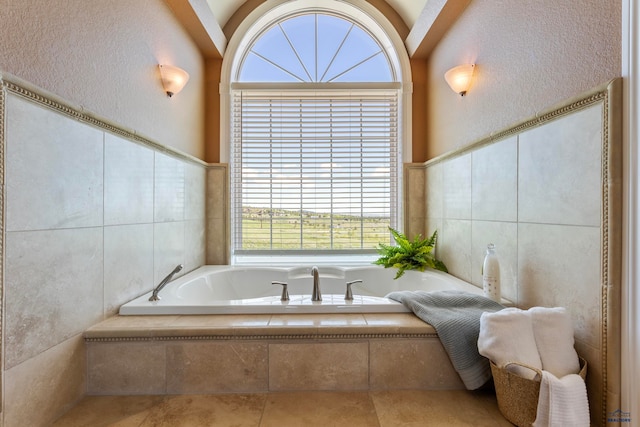 bathroom featuring a relaxing tiled bath, tile walls, and tile floors