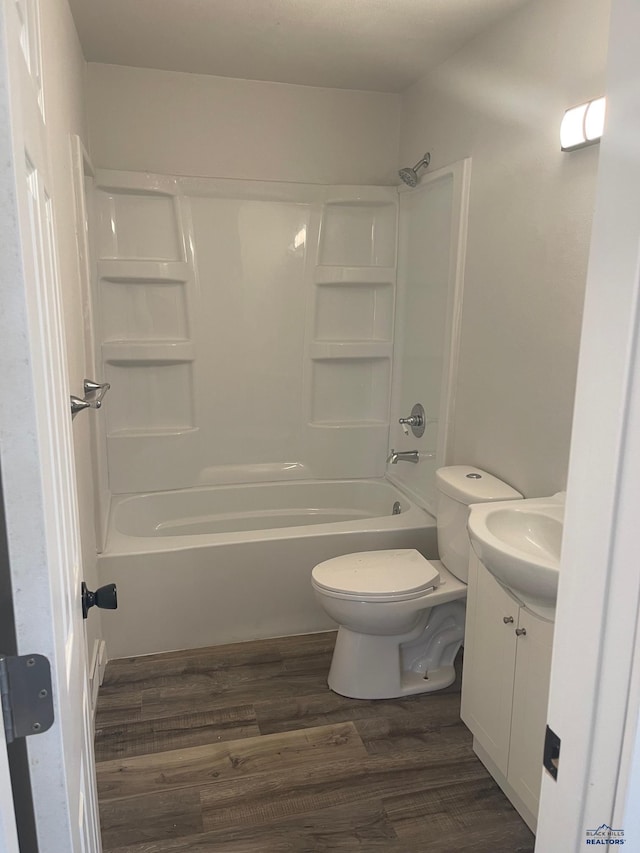 full bathroom featuring toilet, vanity,  shower combination, and hardwood / wood-style flooring