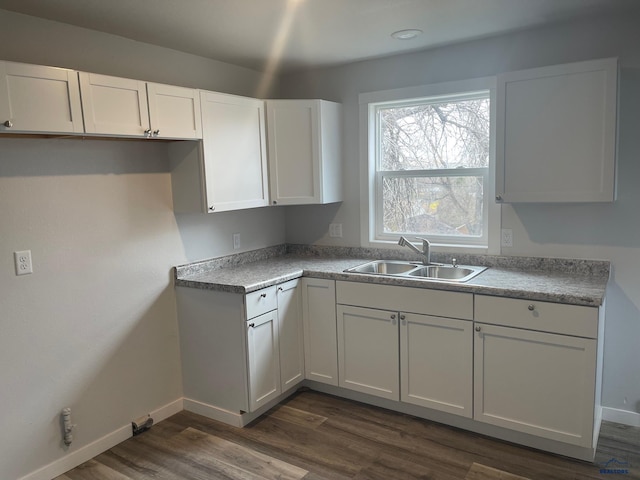 kitchen featuring dark hardwood / wood-style flooring, white cabinetry, and sink