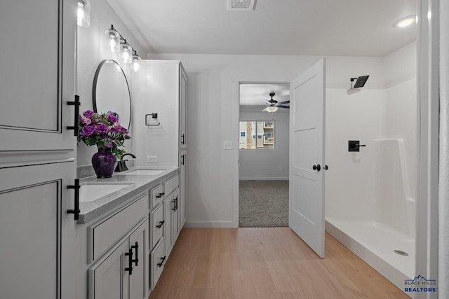 bathroom featuring hardwood / wood-style floors, ceiling fan, vanity, and walk in shower