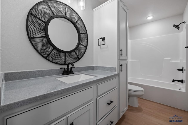 full bathroom featuring toilet, hardwood / wood-style flooring, shower / bath combination, and vanity