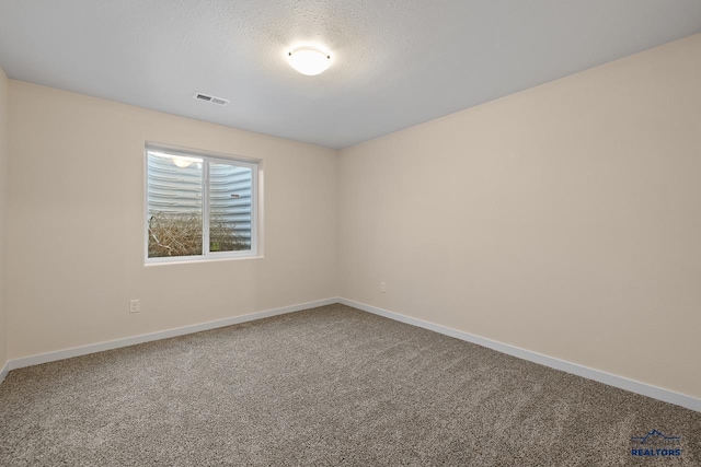 carpeted spare room with a textured ceiling