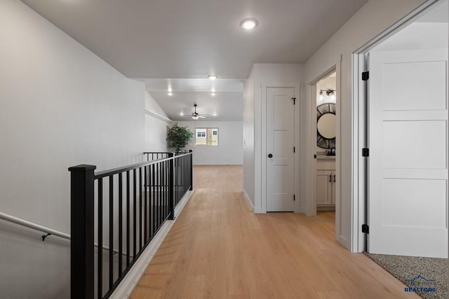 hall featuring lofted ceiling and light hardwood / wood-style floors