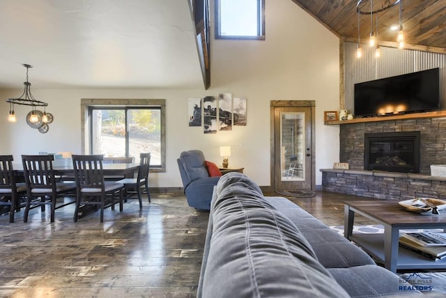 living room featuring dark wood-type flooring, wooden ceiling, vaulted ceiling with beams, and a fireplace