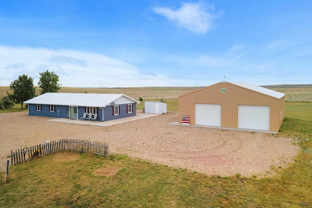 view of front of home with a rural view, an outdoor structure, a front lawn, and a garage