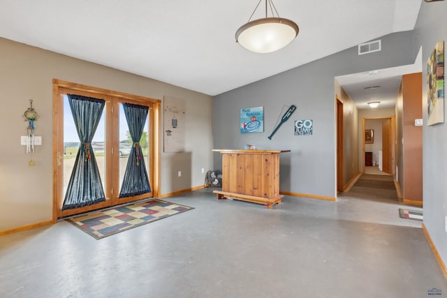 entryway featuring concrete flooring and vaulted ceiling