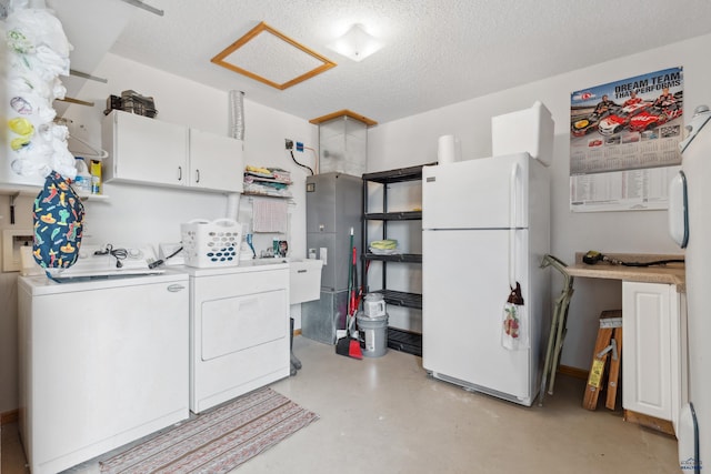 laundry area featuring sink, a textured ceiling, and washing machine and clothes dryer