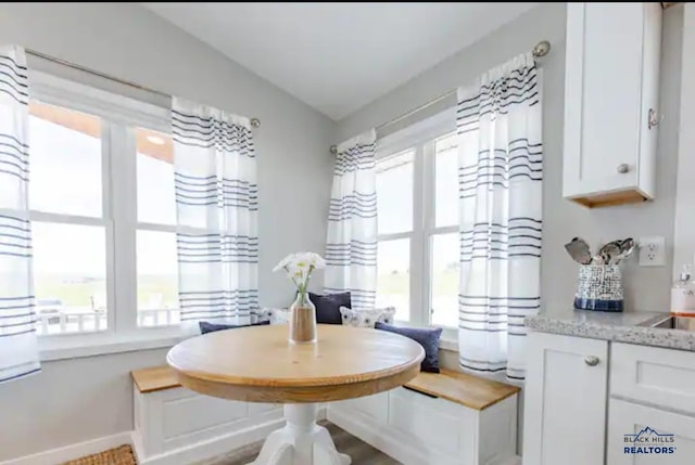 dining room featuring breakfast area, lofted ceiling, and sink