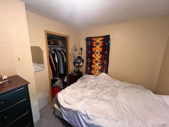 carpeted bedroom with a closet and a textured ceiling