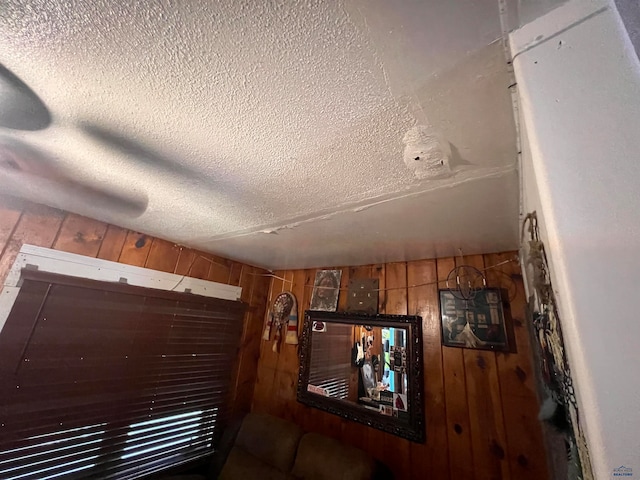 interior details with wood walls and a textured ceiling