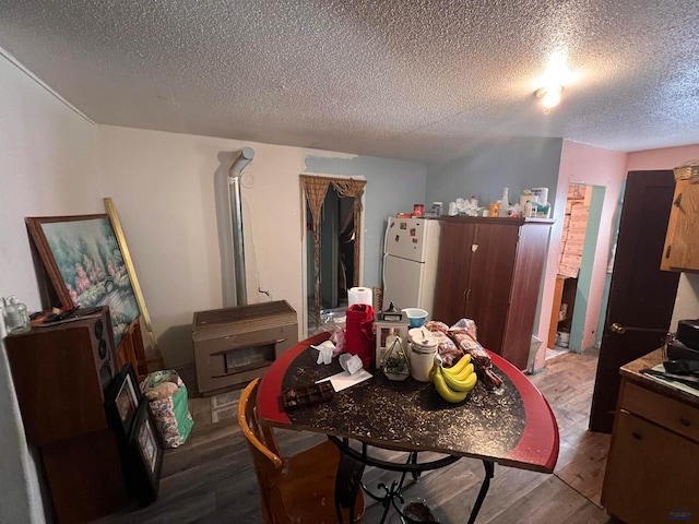 dining space with hardwood / wood-style floors and a textured ceiling