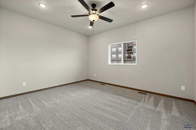 carpeted spare room with ceiling fan