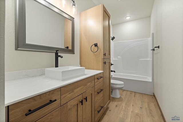 full bathroom featuring wood-type flooring, bathing tub / shower combination, toilet, and vanity