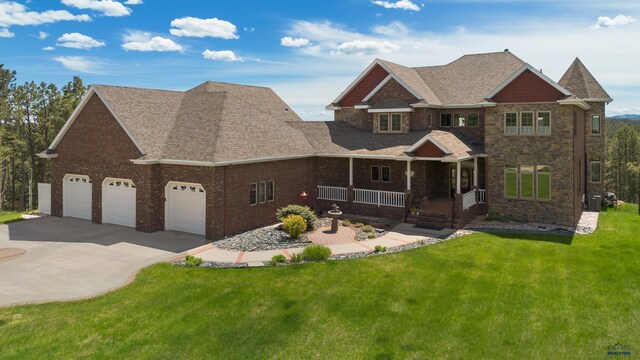 craftsman-style house with a garage, covered porch, and a front yard