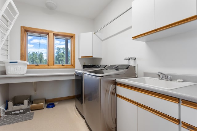 washroom featuring cabinets, sink, and washer and dryer