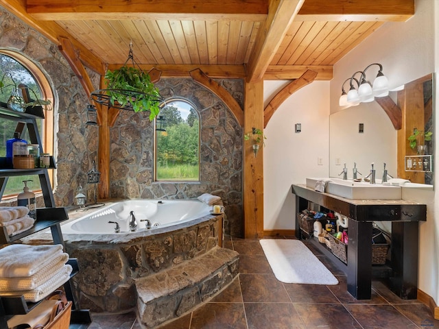 bathroom with beam ceiling, a bathtub, and wooden ceiling