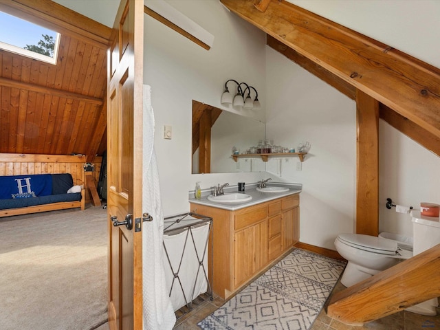 bathroom with wooden walls, double vanity, toilet, lofted ceiling with skylight, and wooden ceiling