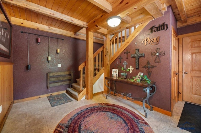 tiled entryway featuring wooden ceiling and beam ceiling